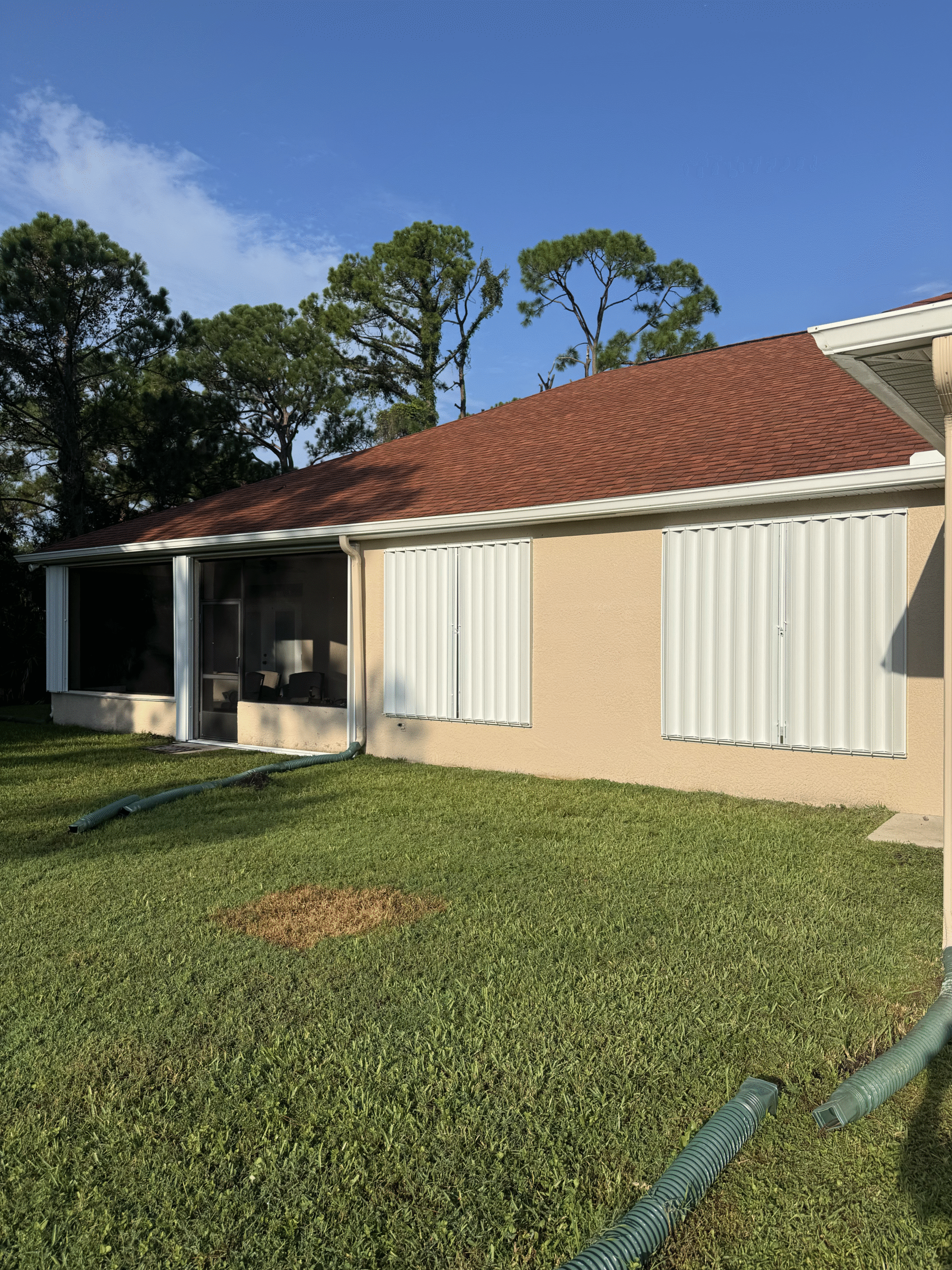 Custom white accordion hurricane shutters installed on a Florida home