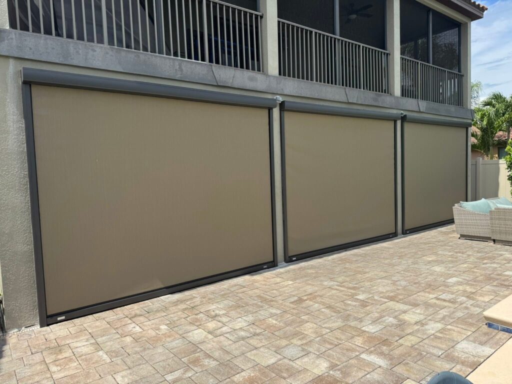 Beige Magnatrack Progressive Hurricane Roll Screen installed next to a luxurious pool, providing motorized shade, privacy, and insect protection in Florida.