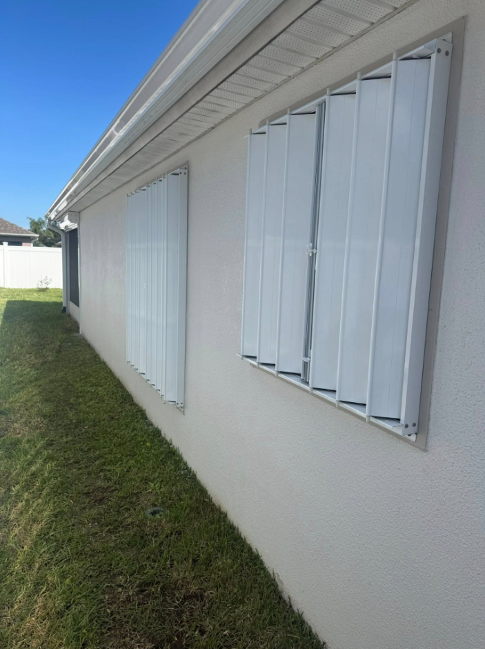 White accordion hurricane shutters installed on a Melbourne, Florida home by Affordable Glass Protection.