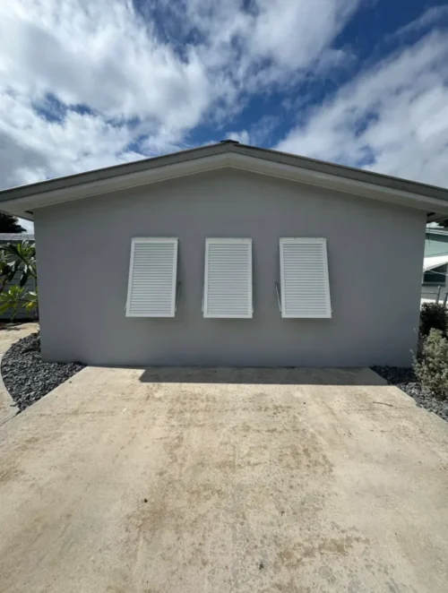 Decorative Bahama shutters installed on a coastal home in Melbourne, Florida — colorful, hurricane rated, and locally manufactured by — installed by Affordable Glass Protection